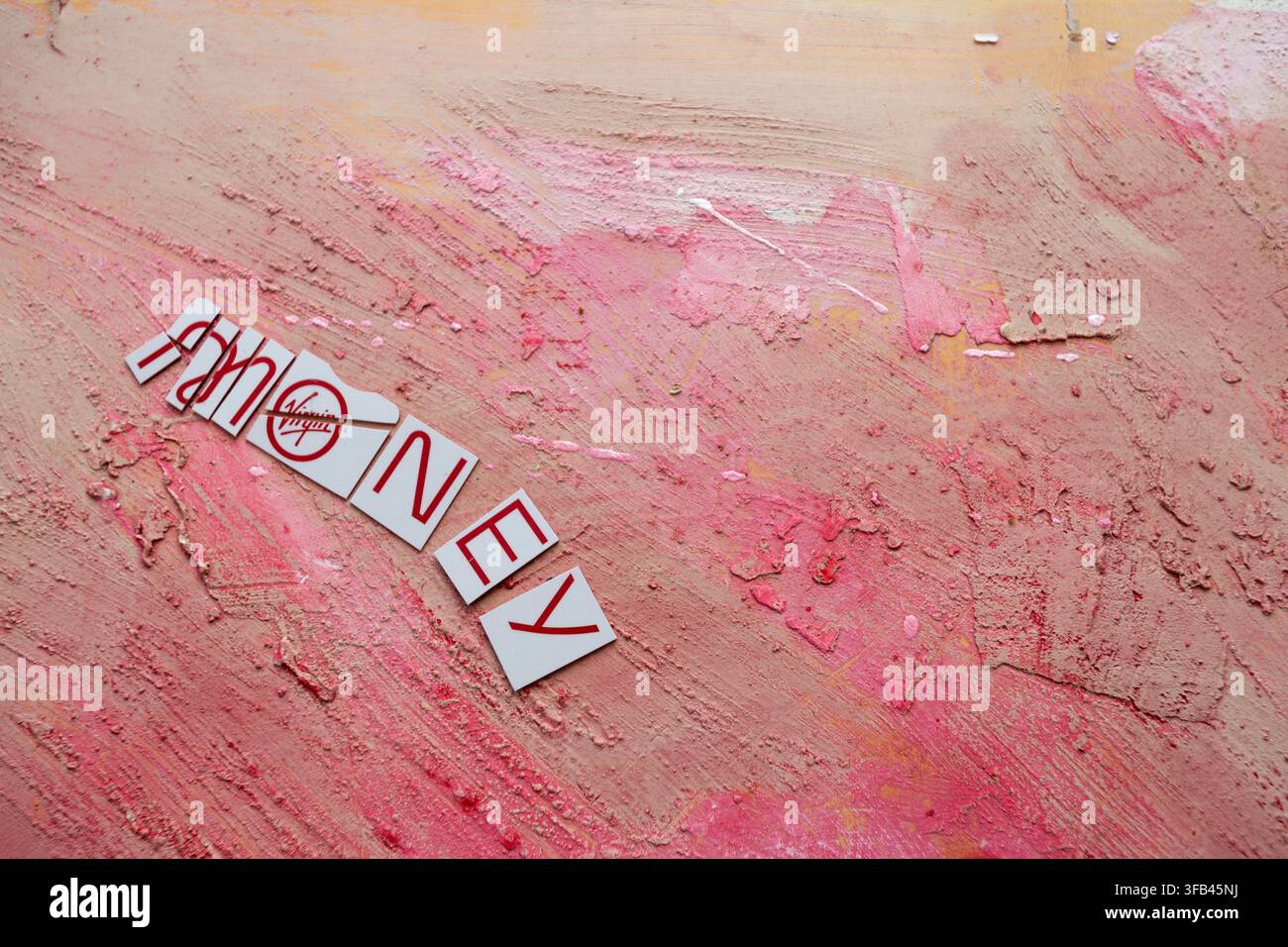 Against a textured red background a Virgin Money Mastercard credit card has been cut in to pieces perhaps too enthusiastically but tidily arranged. Stock Photo