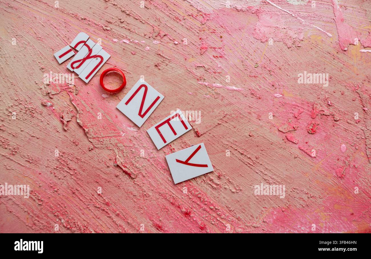 Against a textured red background a Virgin Money Mastercard credit card has been cut in to pieces perhaps too enthusiastically but tidily arranged. Stock Photo