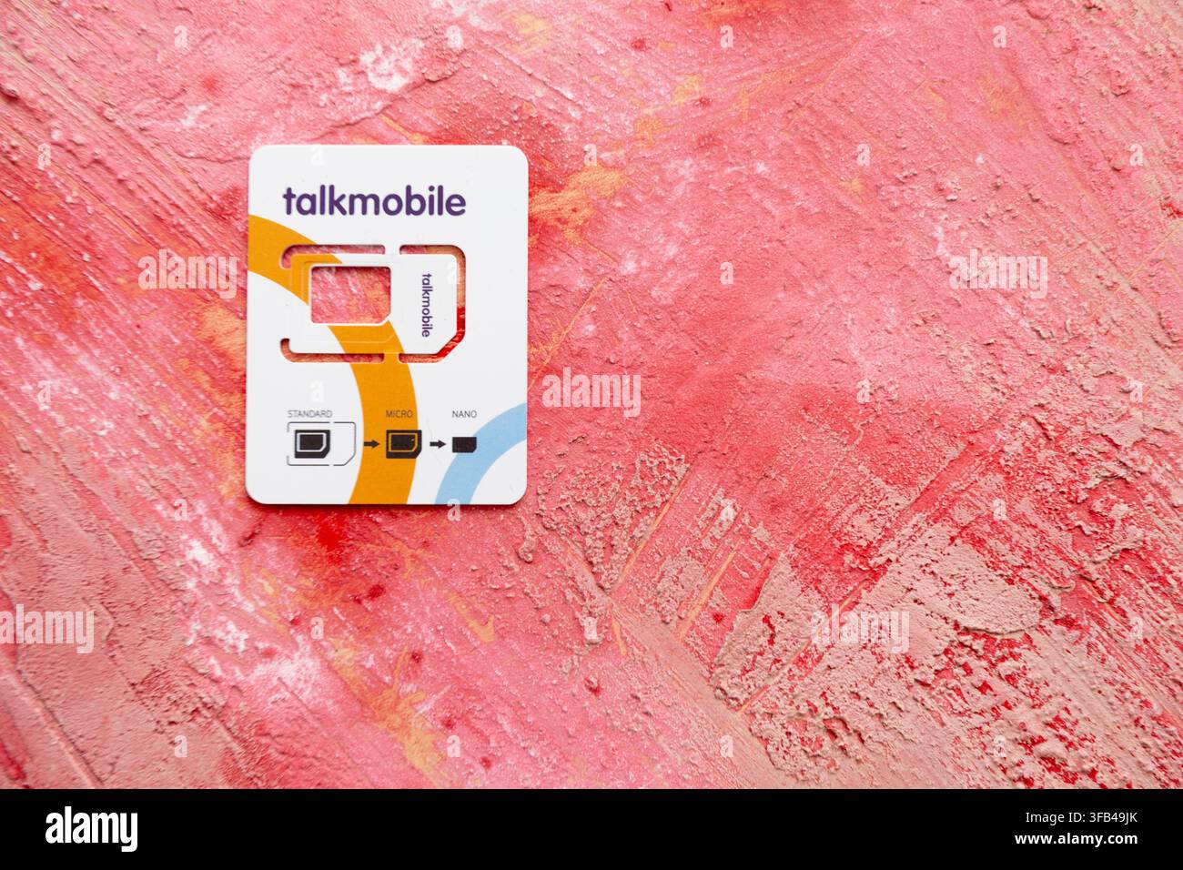 A Talkmobile white plastic holder for the three sizes of SIMM needed by a British mobile phone and reflecting the developing size reduction over time. Stock Photo