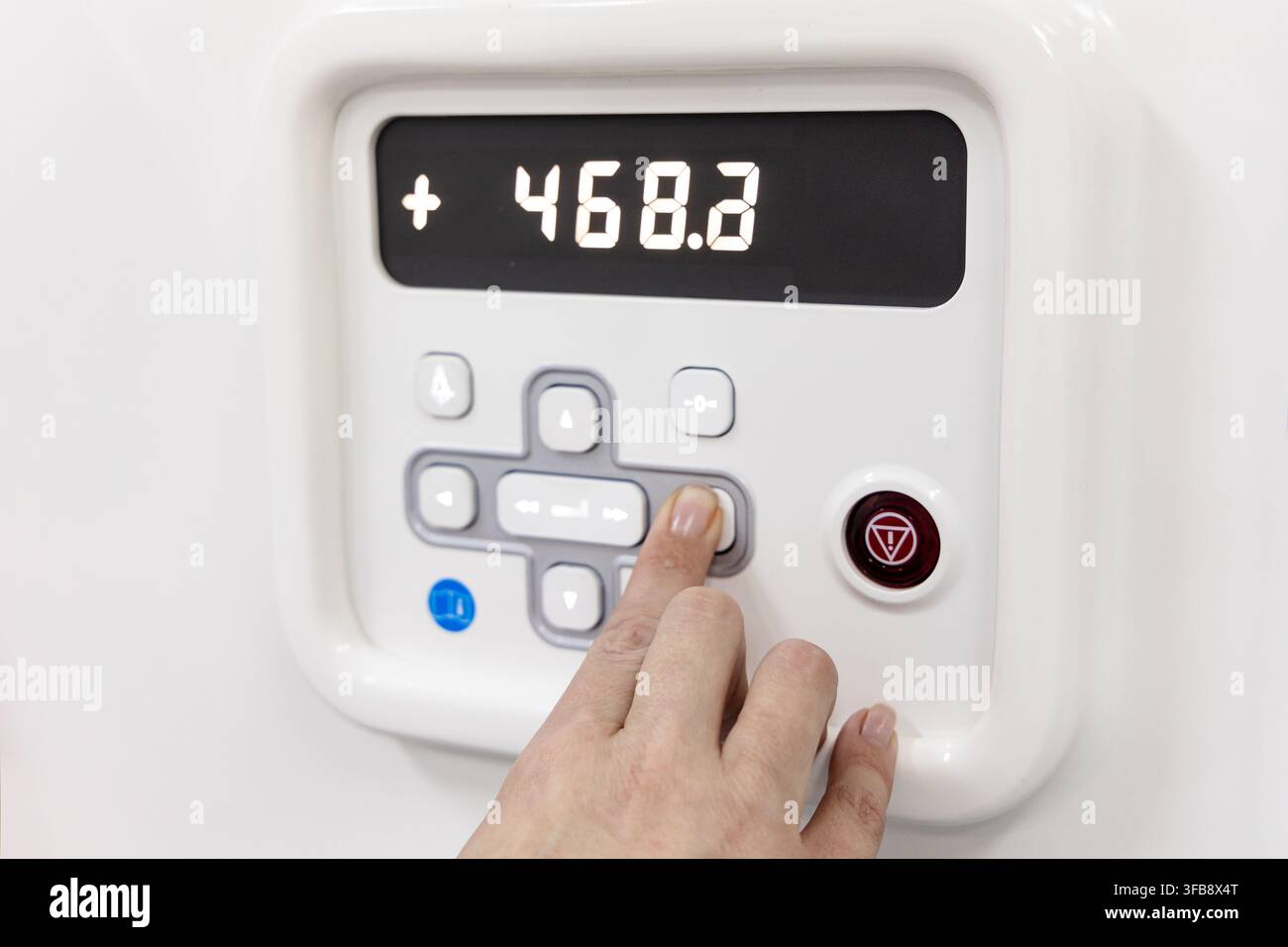 Hand Adjusting Settings on Industrial Machine Digital Control Panel Stock Photo
