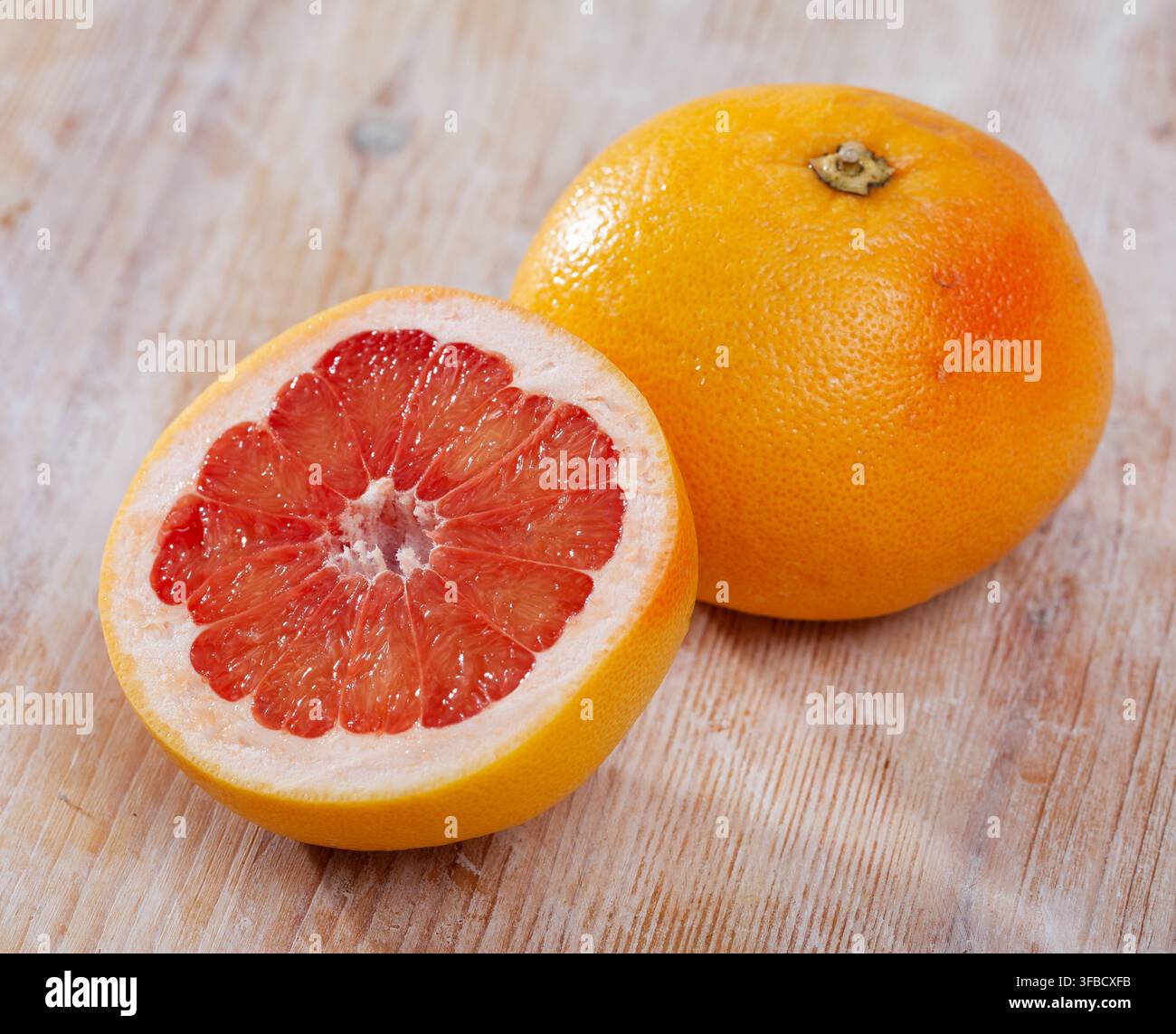 Sliced grapefruit on wooden table Stock Photo