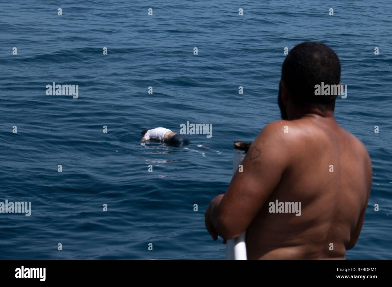 A fisherman looks at a drowned body during a search operation after a ...