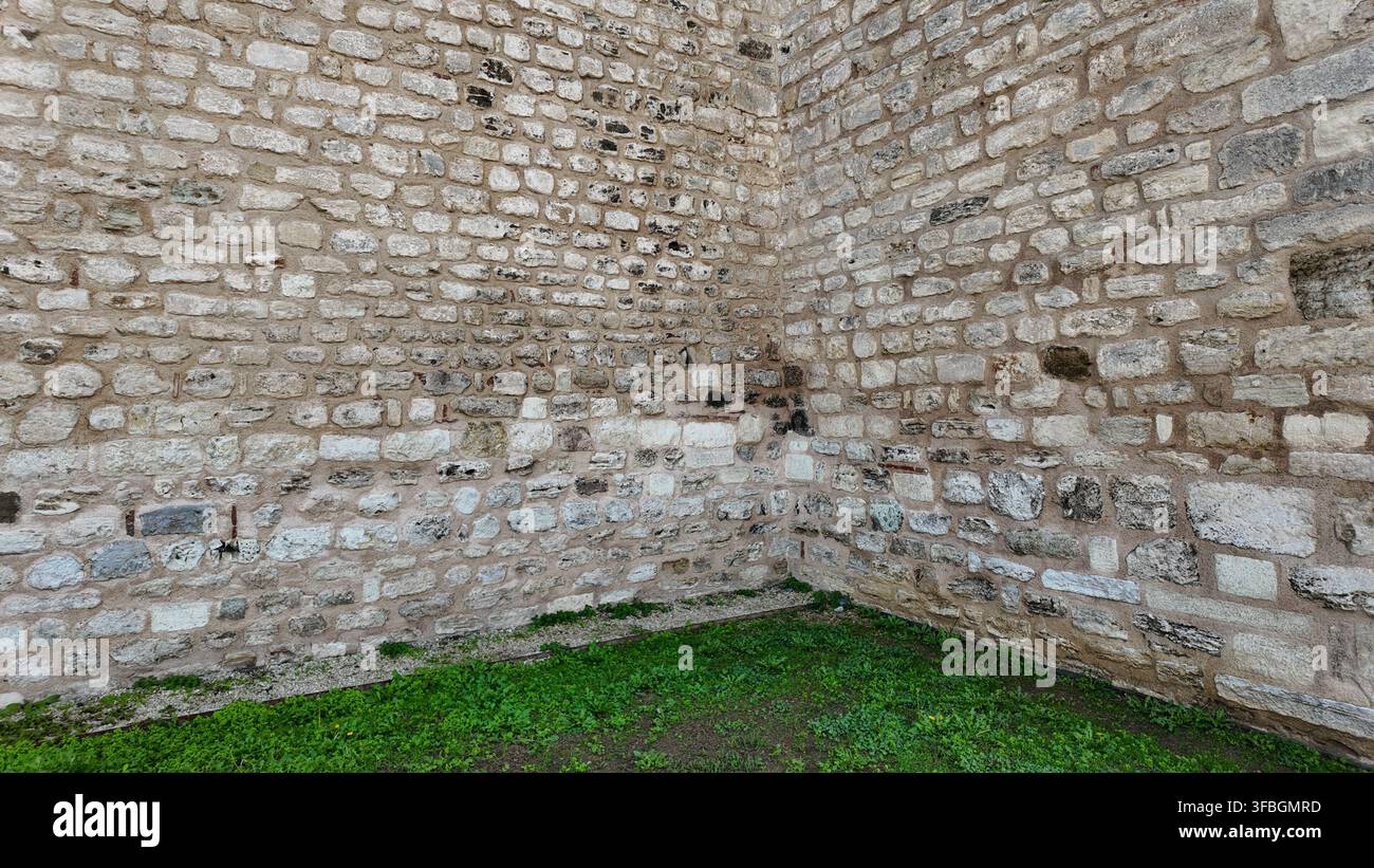 Old stone wall in a grassy area Stock Photo