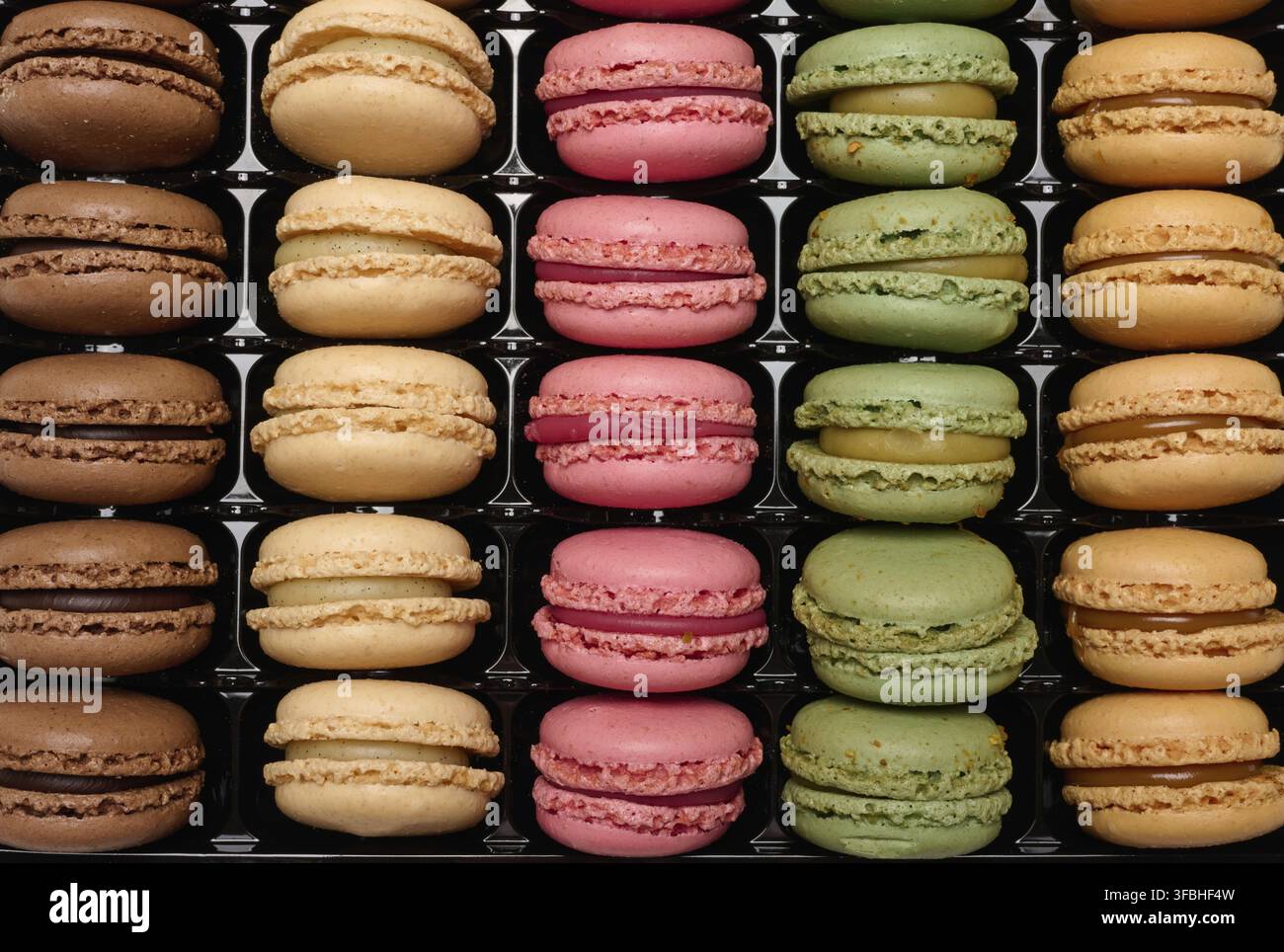 Multi-colored macarons in a plastic box, top view. Assortment Stock Photo