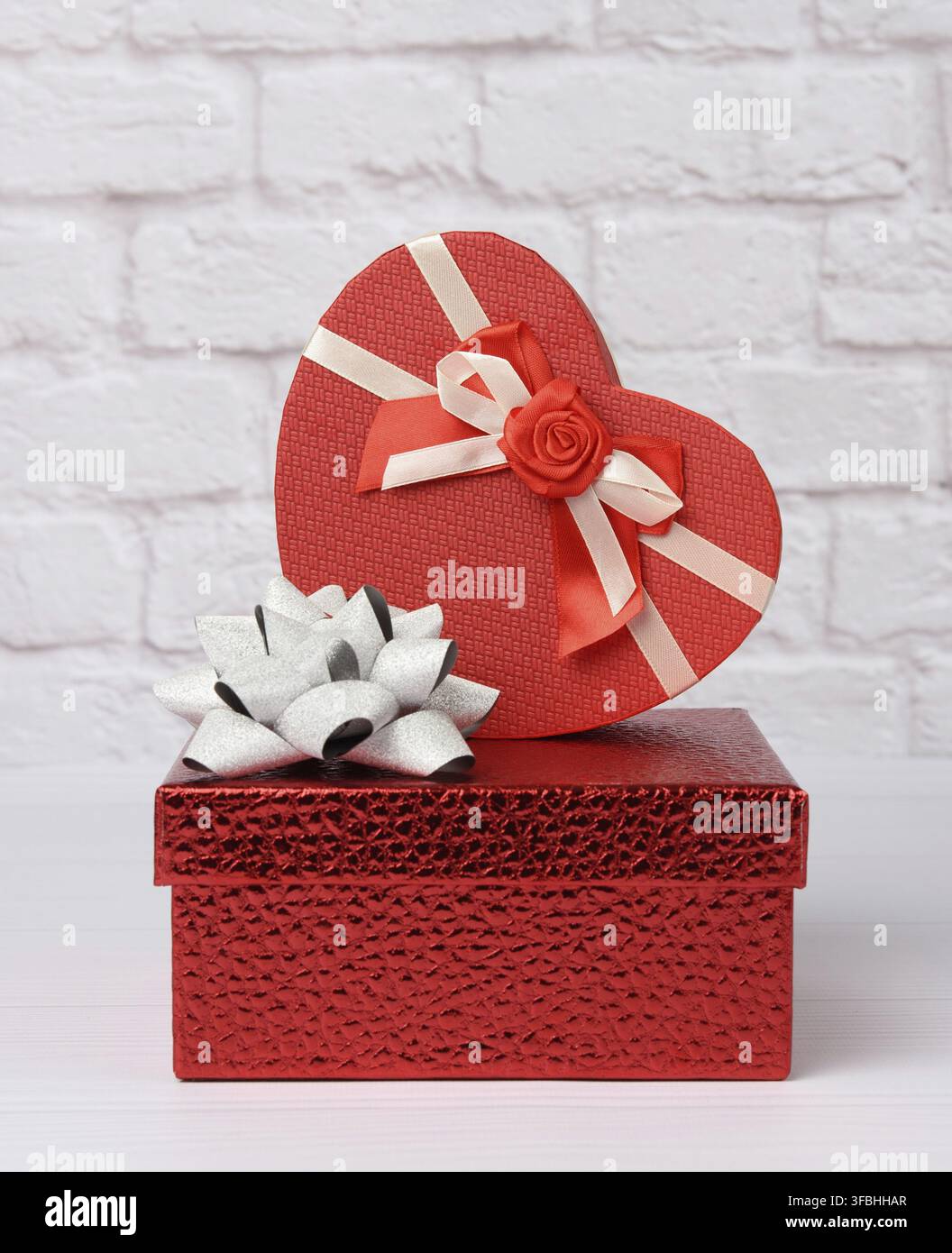 Stack of various red boxes with gifts on white background, festive backdrop Stock Photo