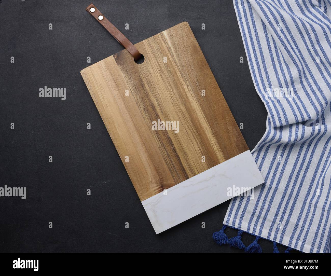 Empty rectangular wooden kitchen cutting board on black table top view Stock Photo
