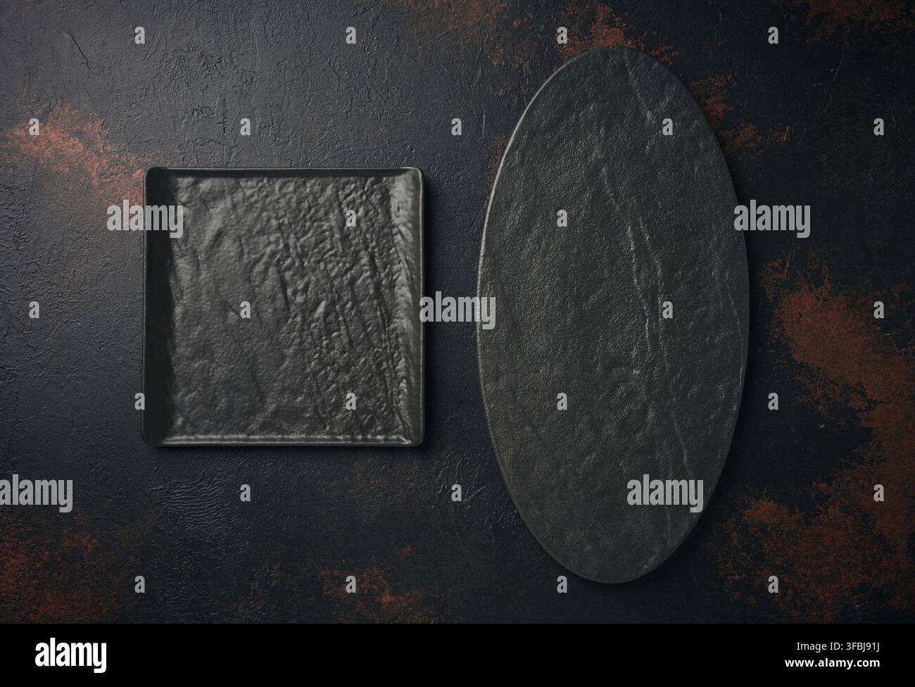 Oval and square stone kitchen board on black background, top view Stock Photo