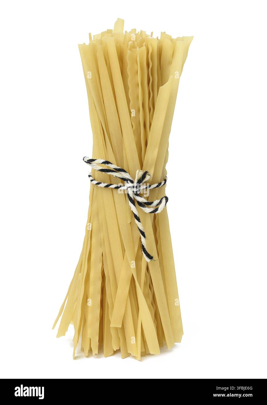 Raw long pasta tied with a rope on a white isolated background Stock Photo