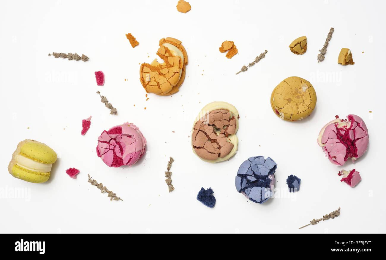Broken round macarons with crumbs on a white background, delicious dessert, top view Stock Photo