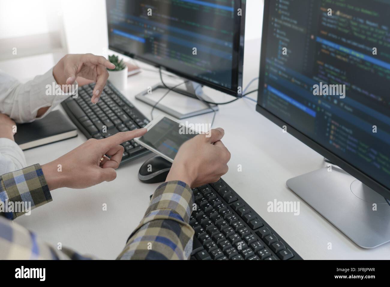 Pensive programmer working on desktop pc programming code technologies or website design at office Software Development Company Stock Photo