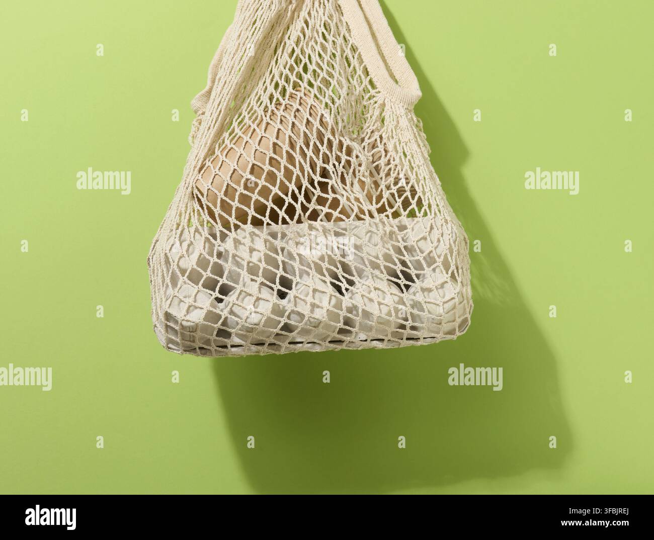 Textile bag with paper cups hanging on a green background. Refusal from plastic bags Stock Photo