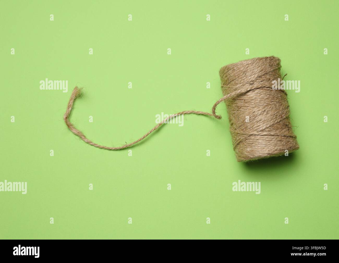 Brown thread spool on a green background, packaging rope Stock Photo