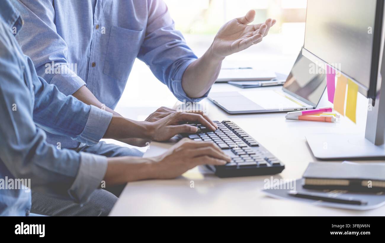 Young startup Programmers Sitting At Desks Working On Computers screen for Developing programming and coding to find solution to problem on New Applic Stock Photo