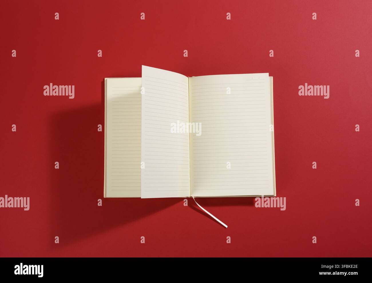 Open notebook with blank white sheets on red background, top view Stock Photo