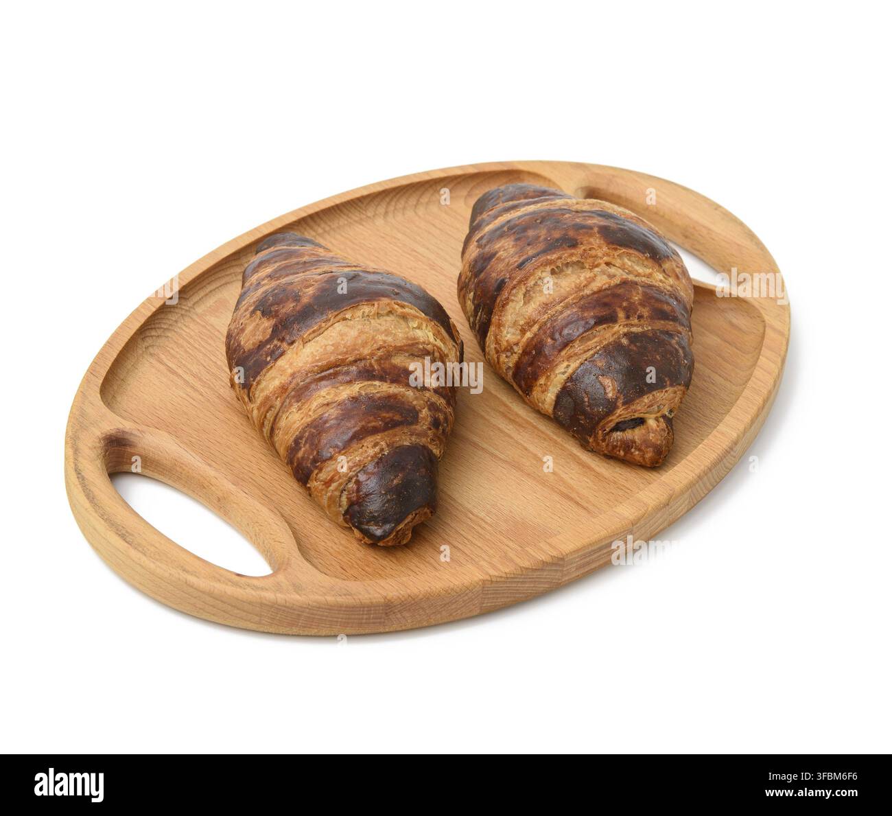 Two baked croissants lie on a wooden tray, food isolated on white background Stock Photo