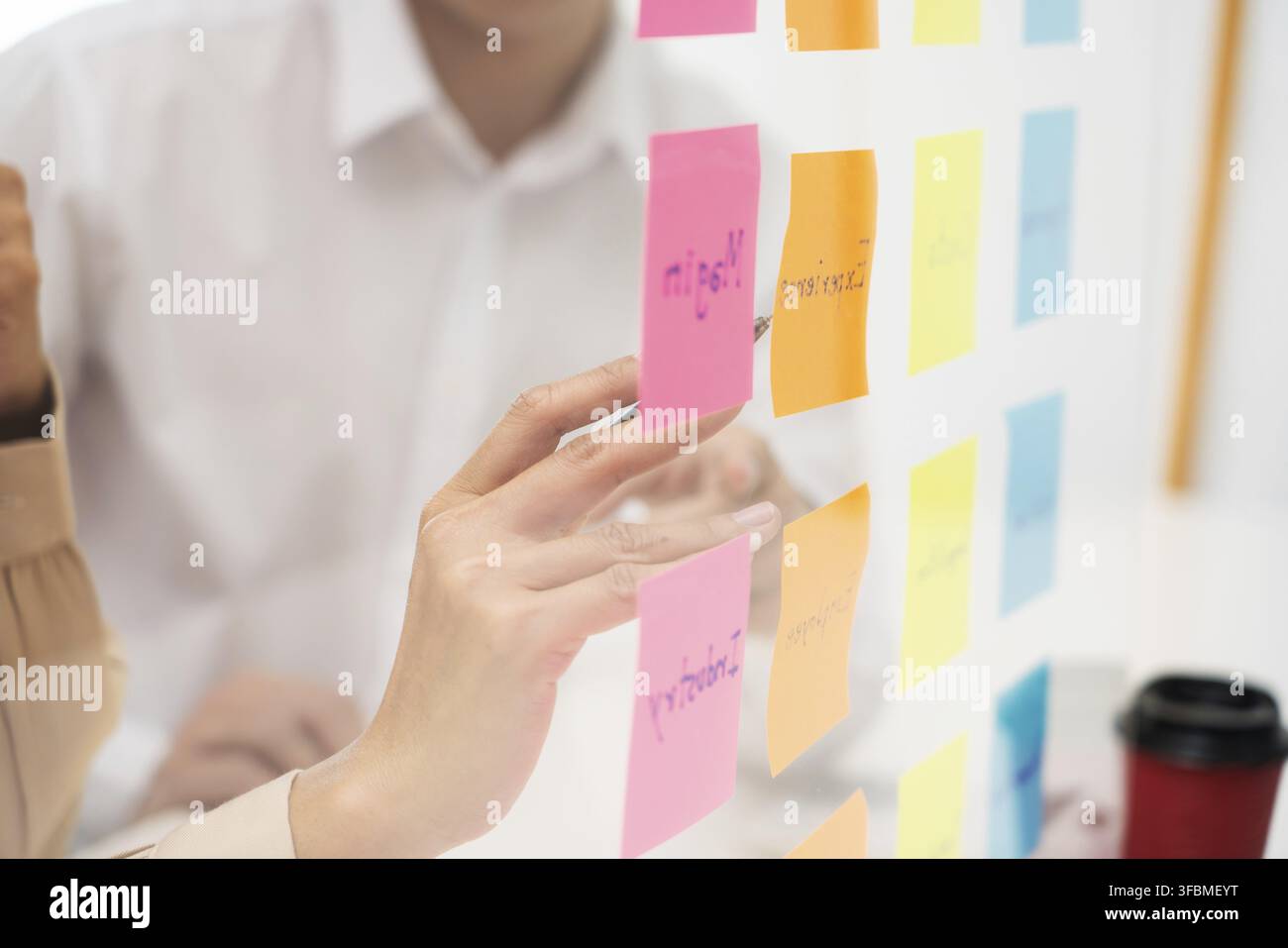 Creative group of business people brainstorming use sticky notes to share idea on glass window or table in office Stock Photo