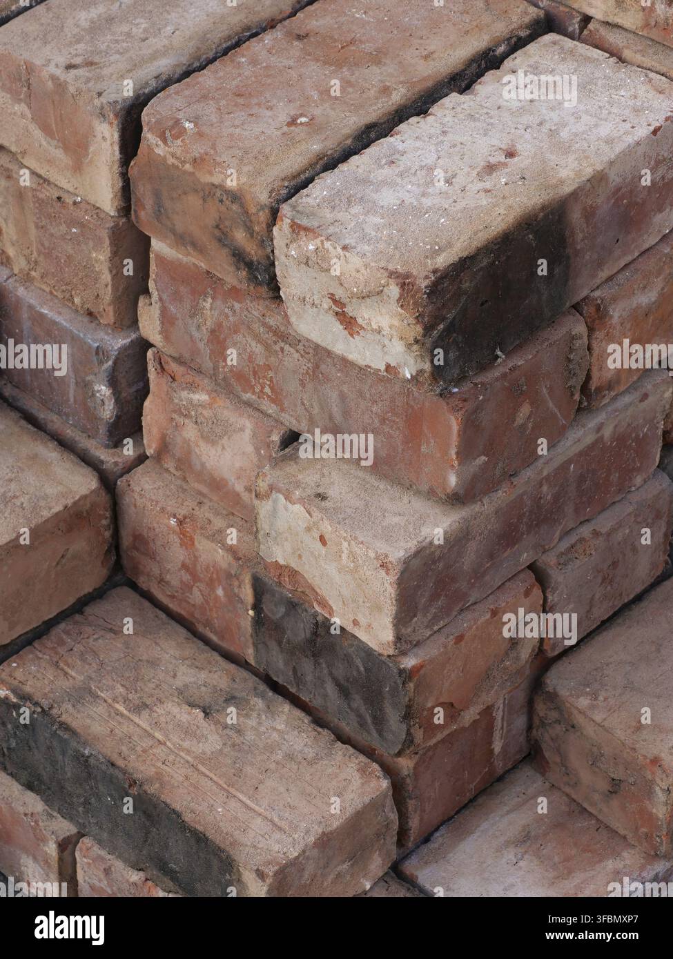An isometric stack of various reclaimed house bricks Stock Photo