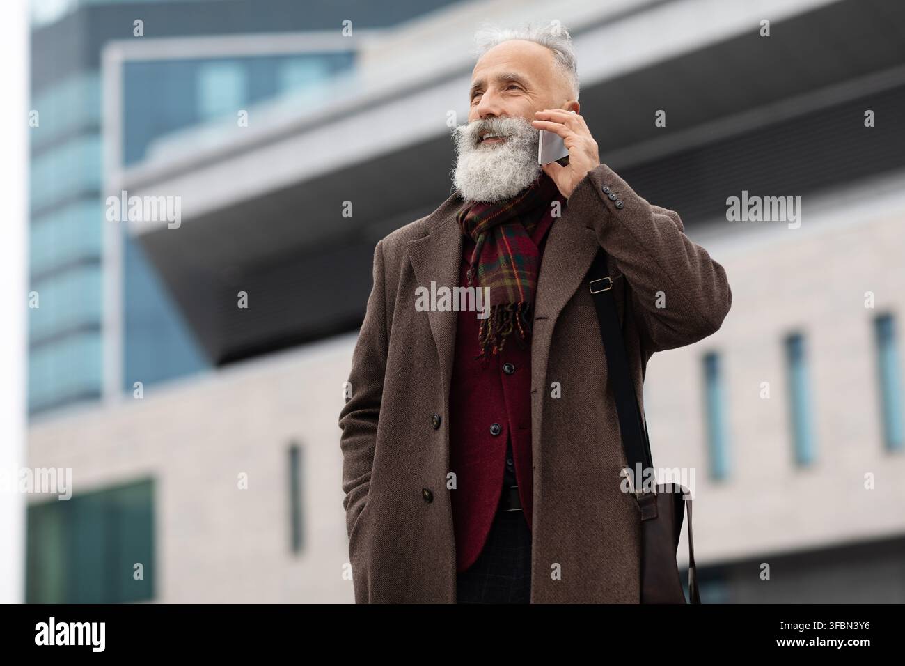 Wealthy senior man having conversation on phone outdoors Stock Photo