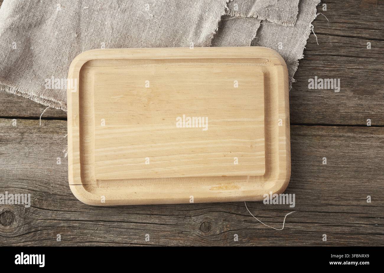 Light beige rectangular empty cutting kitchen board on a wooden background from old boards, top view Stock Photo