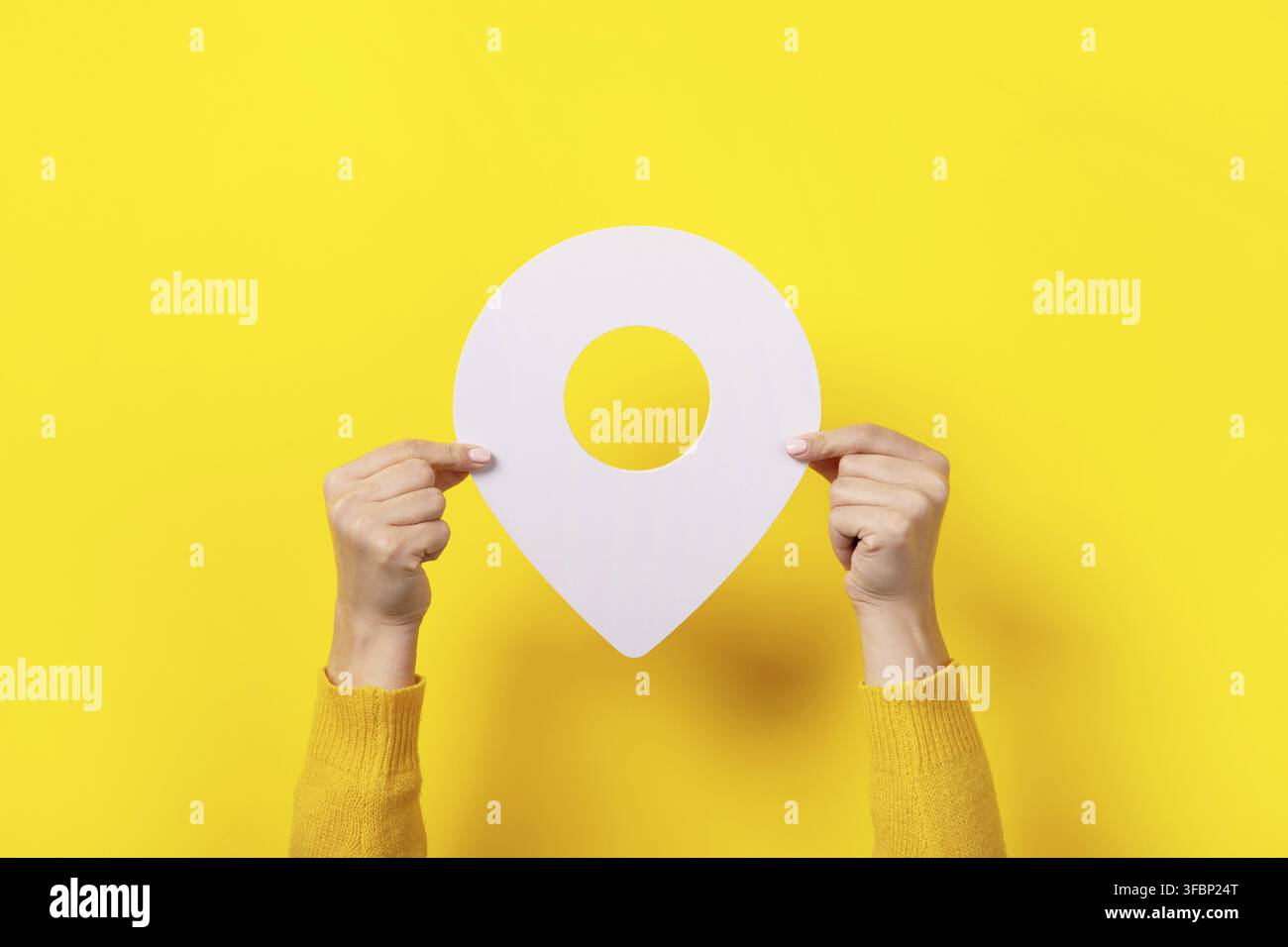 White map pointer 3d pin in hand over yellow background Stock Photo