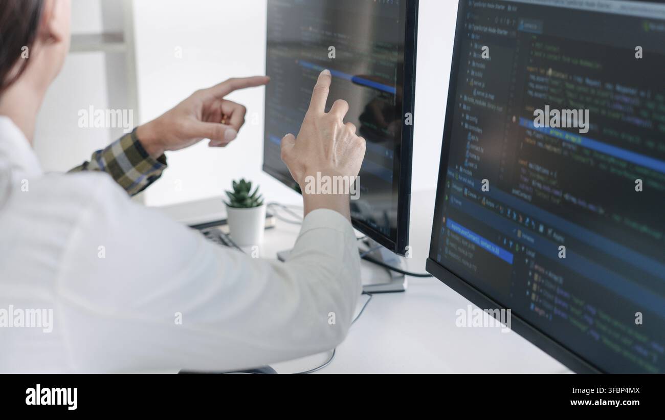 Young startup Programmers Sitting At Desks Working On Computers screen for Developing programming and coding to find solution to problem on New Applic Stock Photo