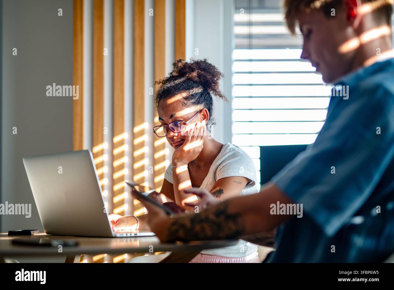 University students working together on laptop during study session. Stock Photo