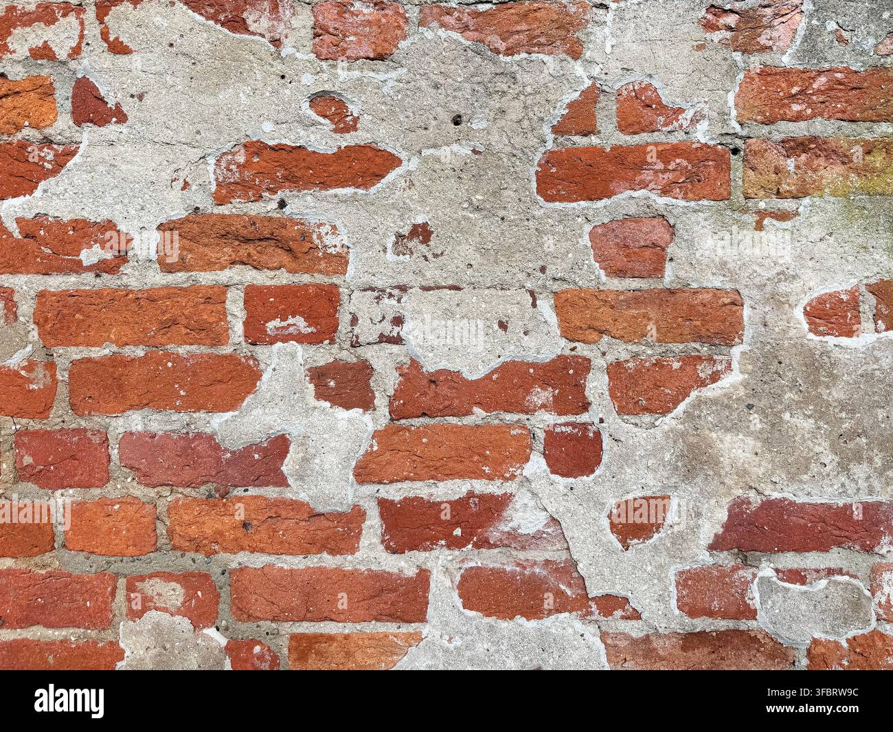 Old red brick wall texture with peeling plaster Stock Photo