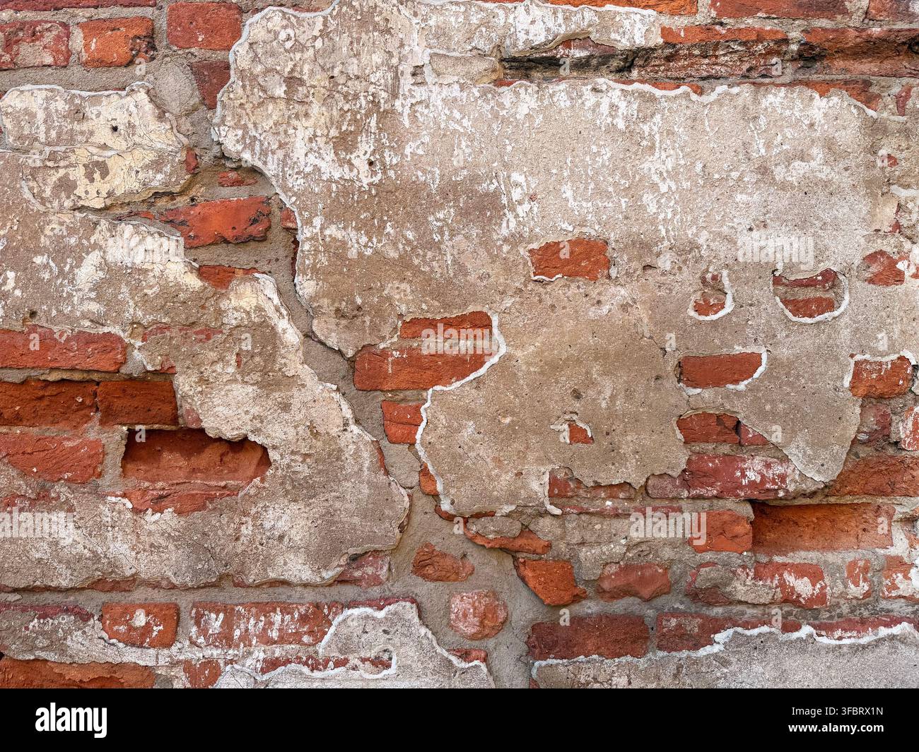 Old red brick wall texture with peeling plaster Stock Photo