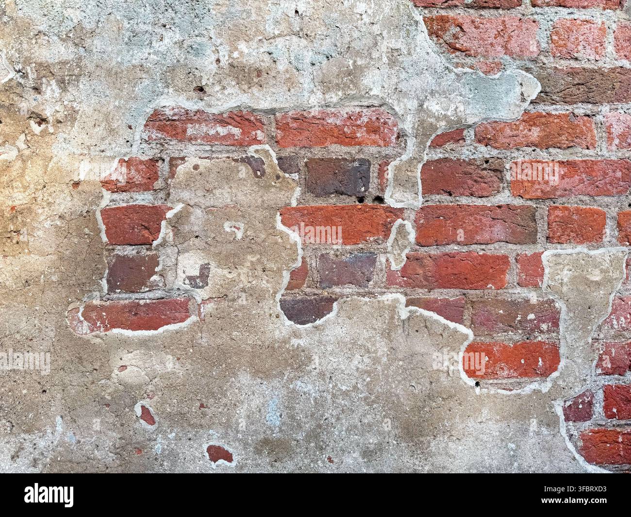 Old red brick wall texture with peeling plaster Stock Photo