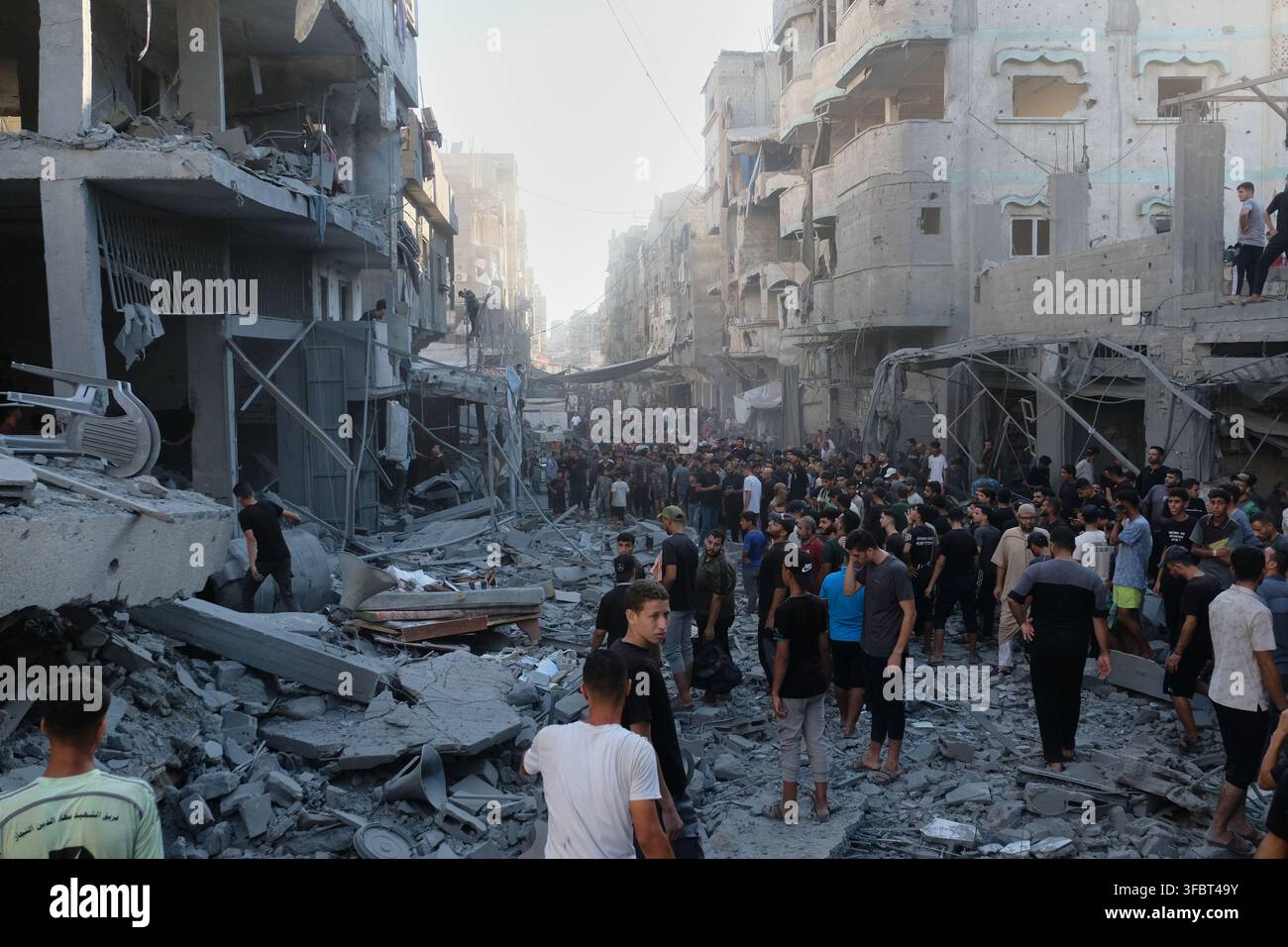 Palestinians inspect the rubble of a building destroyed in an Israeli ...