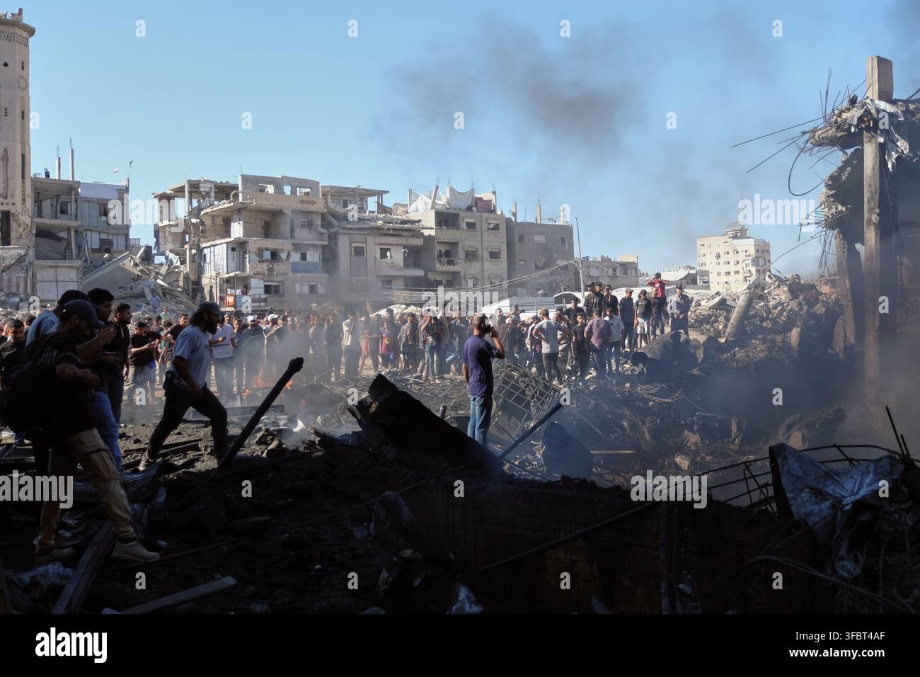 Palestinians inspect the rubble of a building destroyed in an Israeli ...