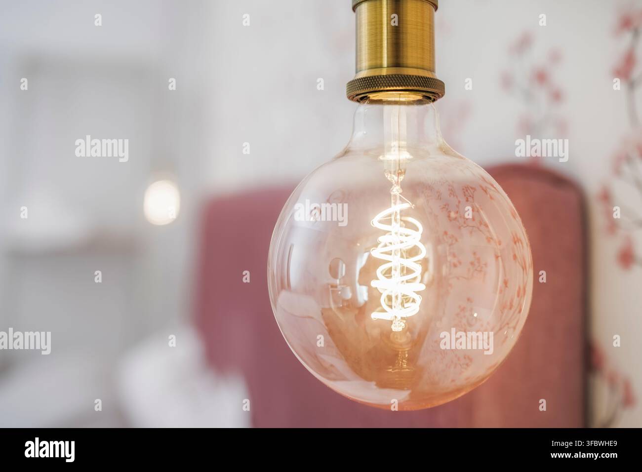 Vintage Edison bulb glowing inside a warm interior Stock Photo