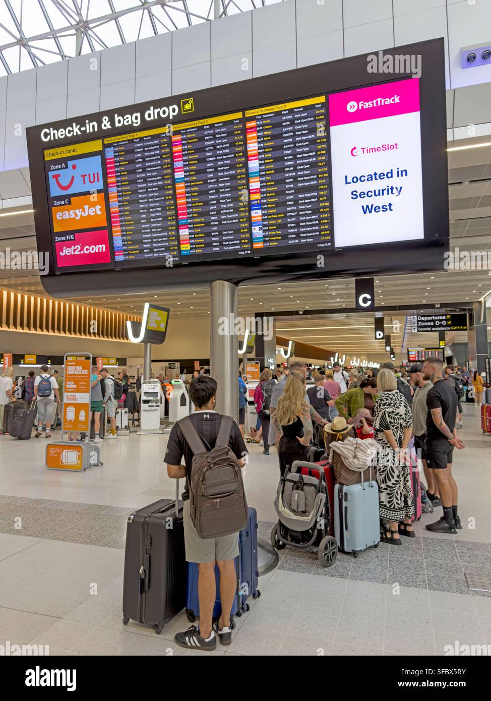 Busy bank-holiday check-in and bag-drop area in Terminal 2 at Manchester Airport, England, UK. Stock Photo