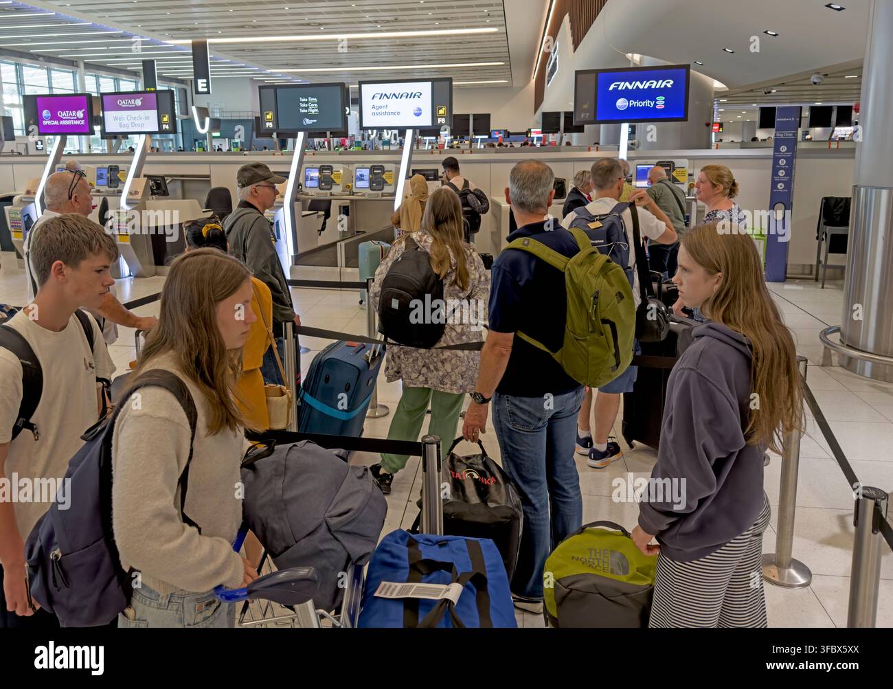 Passengers check in large and irregular baggage in Terminal 2 at Manchester Airport, England, UK. Stock Photo