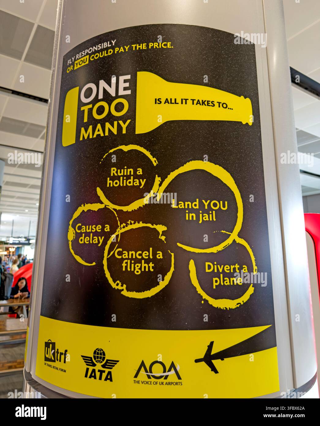 Large black-and-yellow One Too Many poster at Manchester Airport warning passengers against excessive drinking and disruptive behaviour before flying Stock Photo