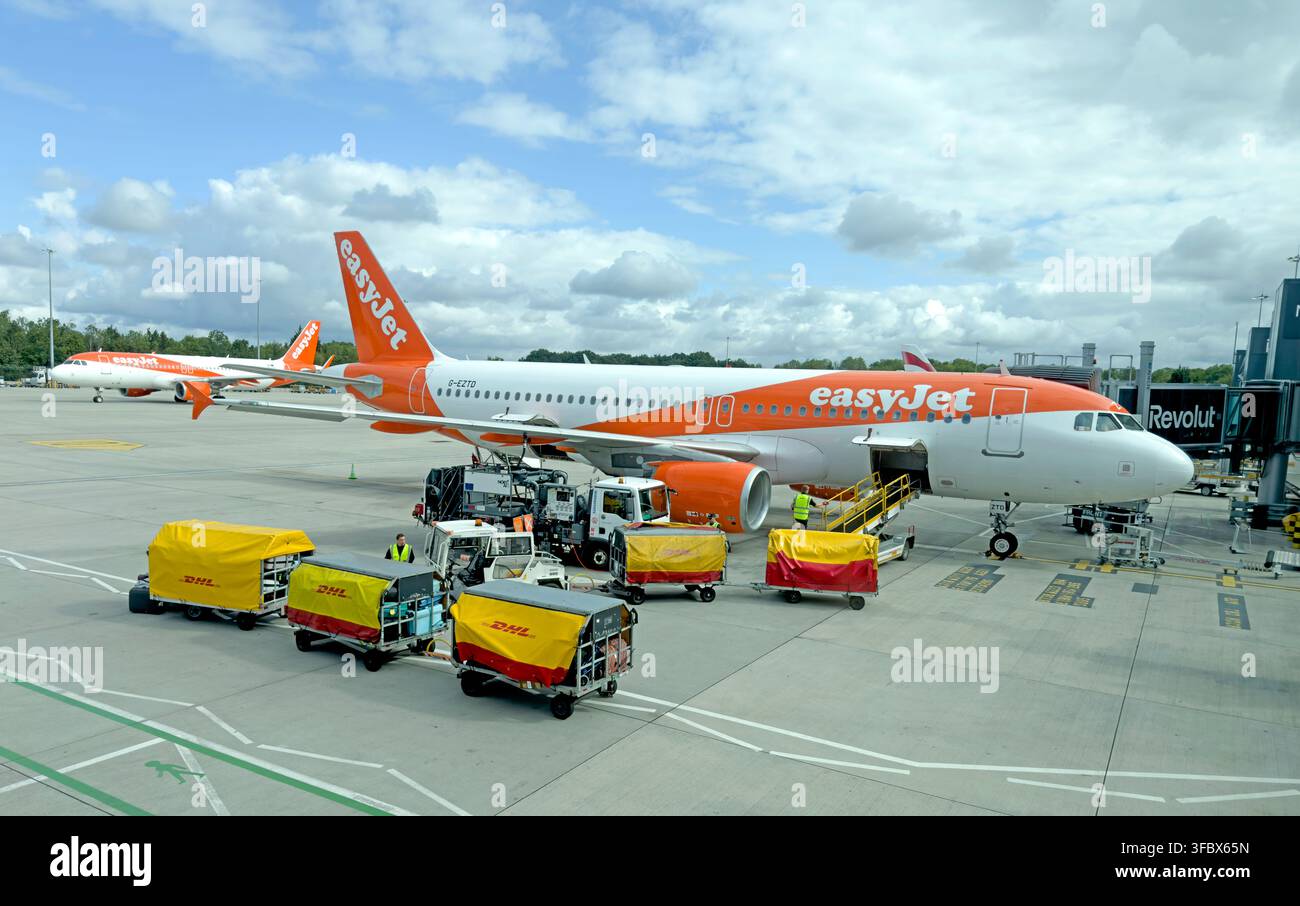 easyJet Airbus G-EZTD on the apron at Manchester Airport as ground crews load baggage before departure. Stock Photo