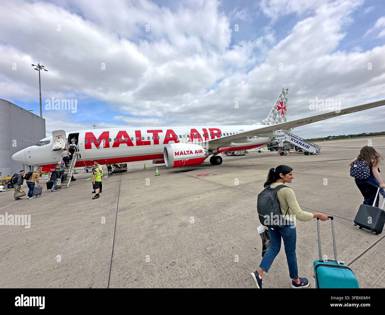 Passengers walk beside a Malta Air Boeing 737, Ryanair Group airline, amid renewed attention to aviation safety after a July 2026 window incident Stock Photo