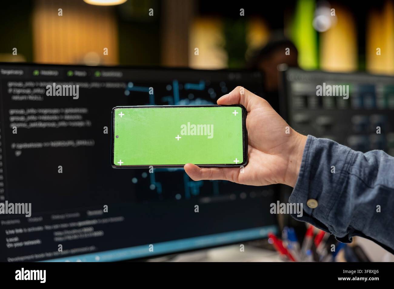 Close up of admin using isolated screen smartphone, debugging software issues and improving system stability. IT professional in tech startup office typing on touchscreen chroma key phone Stock Photo