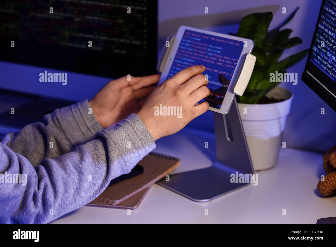 Female programmers hands testing code on tablet computer in office at night, closeup Stock Photo