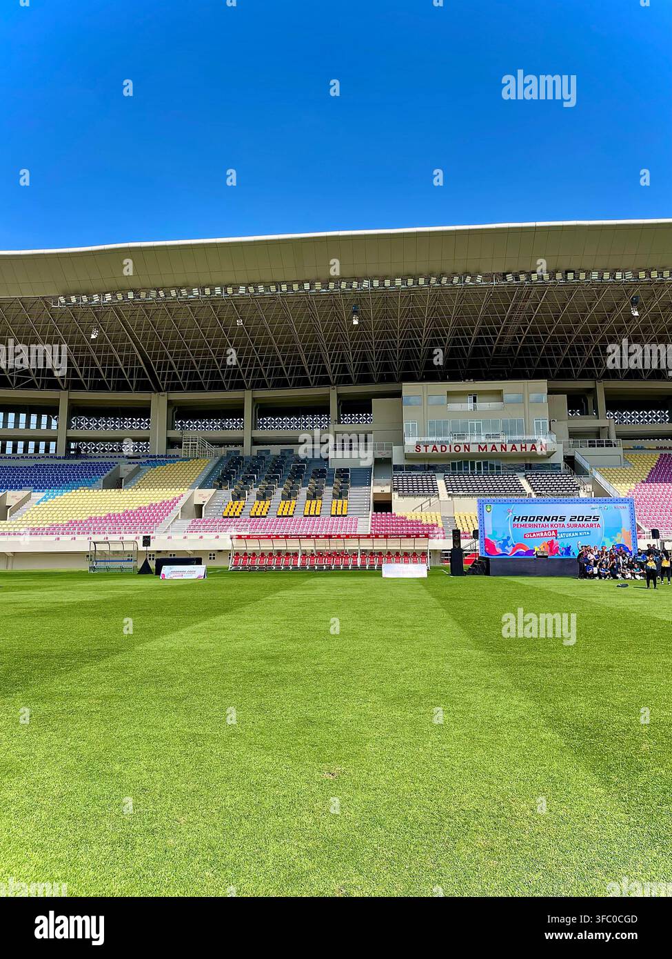 Manahan Stadium in Surakarta, Central Java, Indonesia, showing the football field, spectator stands and an event banner. - Smartphone Captured Stock Image