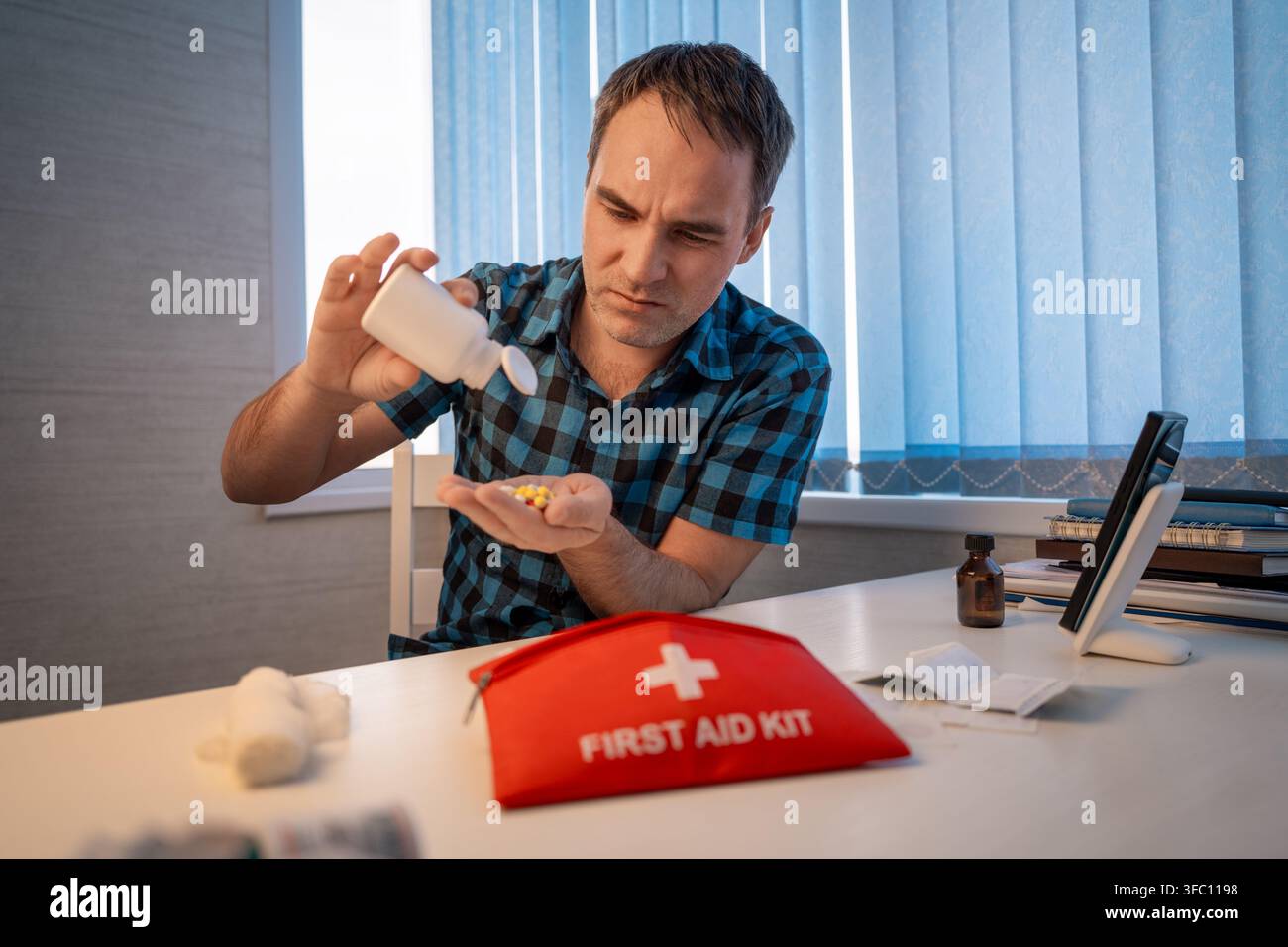 First aid kit, a set of various medicines collected in a red bag, pills for pain, an elastic bandage, a man holds a first-aid kit in his hands, hiking Stock Photo