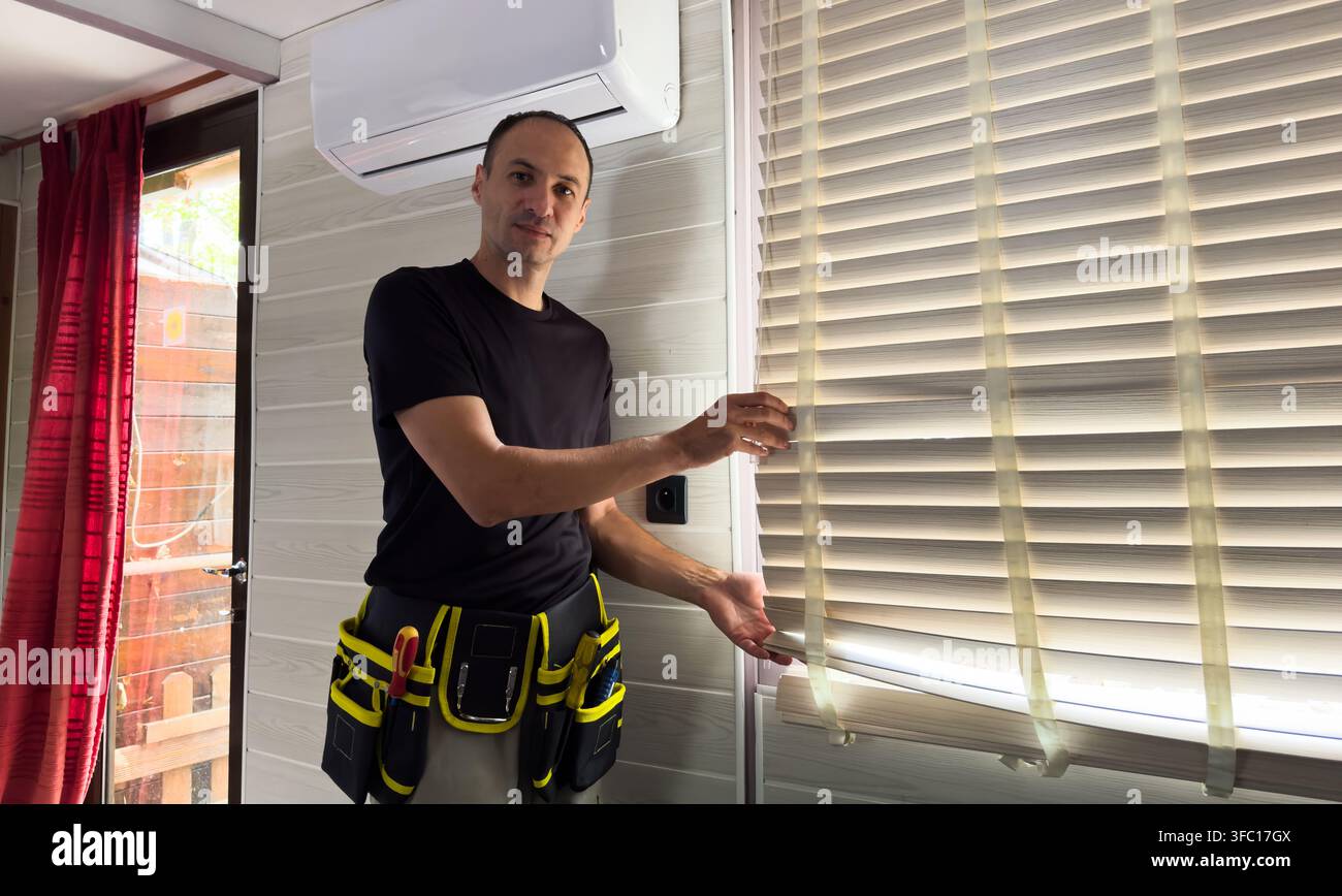 Male hands installing roller blinds on window  Stock Photo