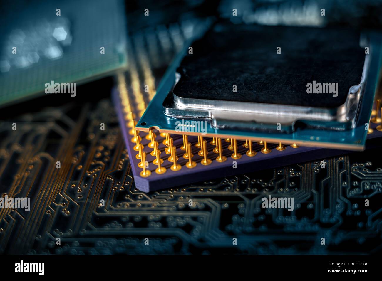 Two computer processors sit on a circuit board in a workspace. The setup highlights electronic components and technology. Stock Photo