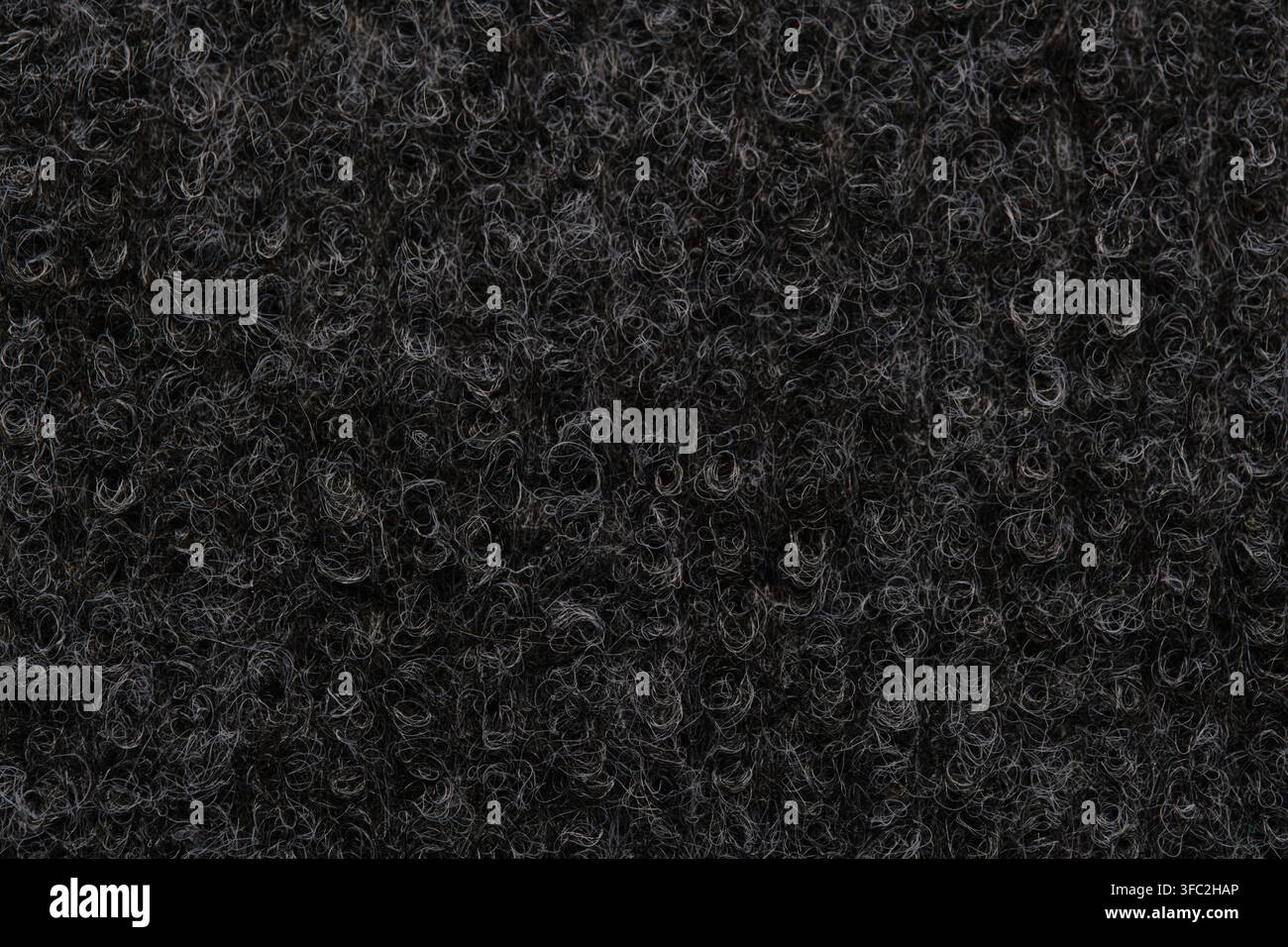 Macro close up texture dark curly synthetic wool or loop pile carpet fibers background pattern Stock Photo