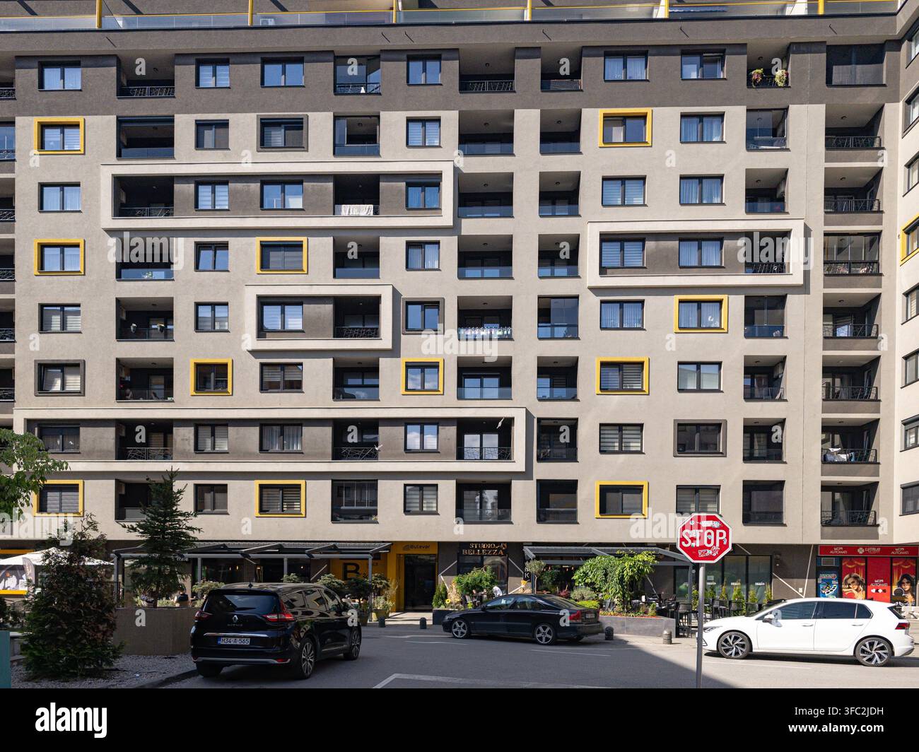 A contemporary, geometric residential building facade with contrasting windows in the Bulevar area, showcasing modern urban living and organized daily - Smartphone Captured Stock Image