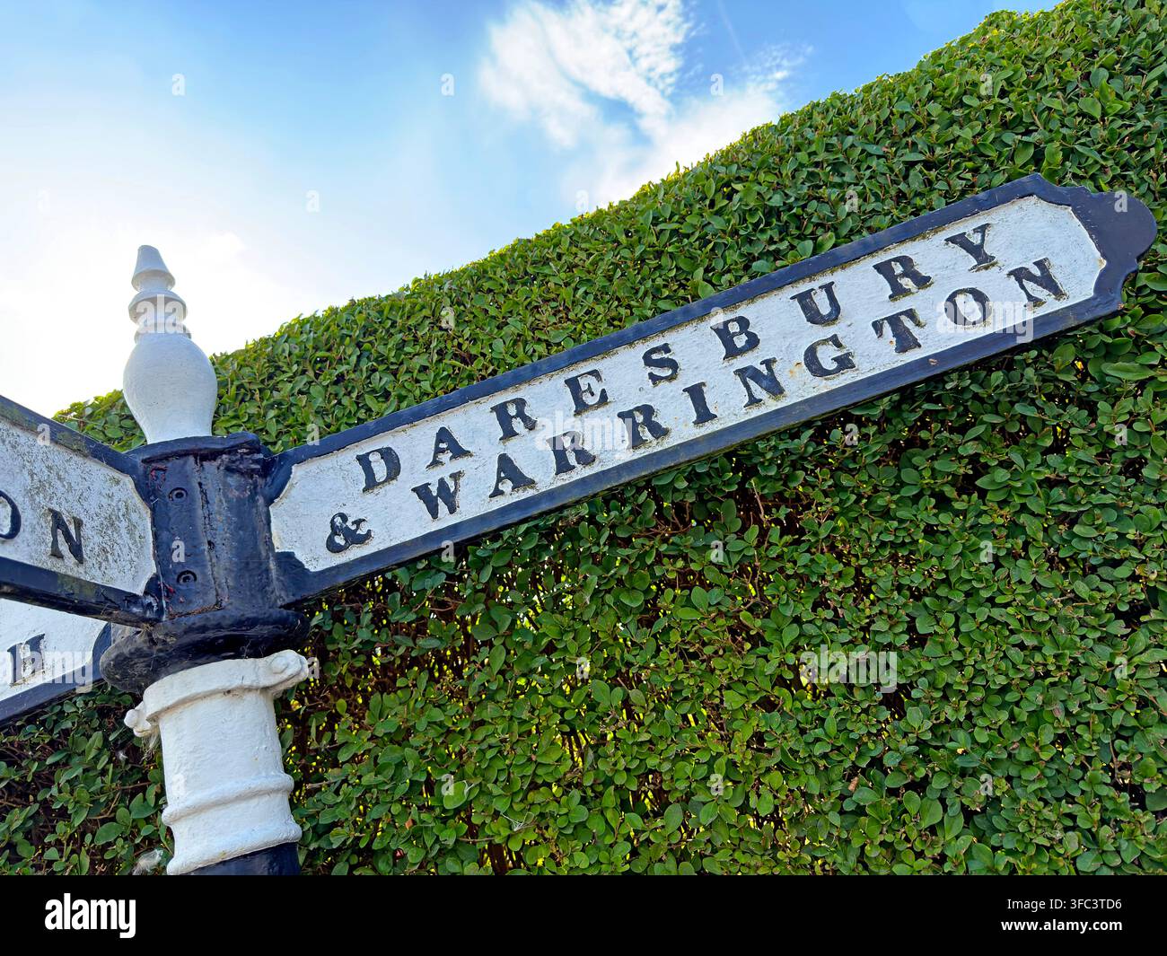 Traditional fingerpost for Daresbury and Warrington in Cheshire, village home of Lewis Carroll heritage and the annual Creamfields festival. Stock Photo