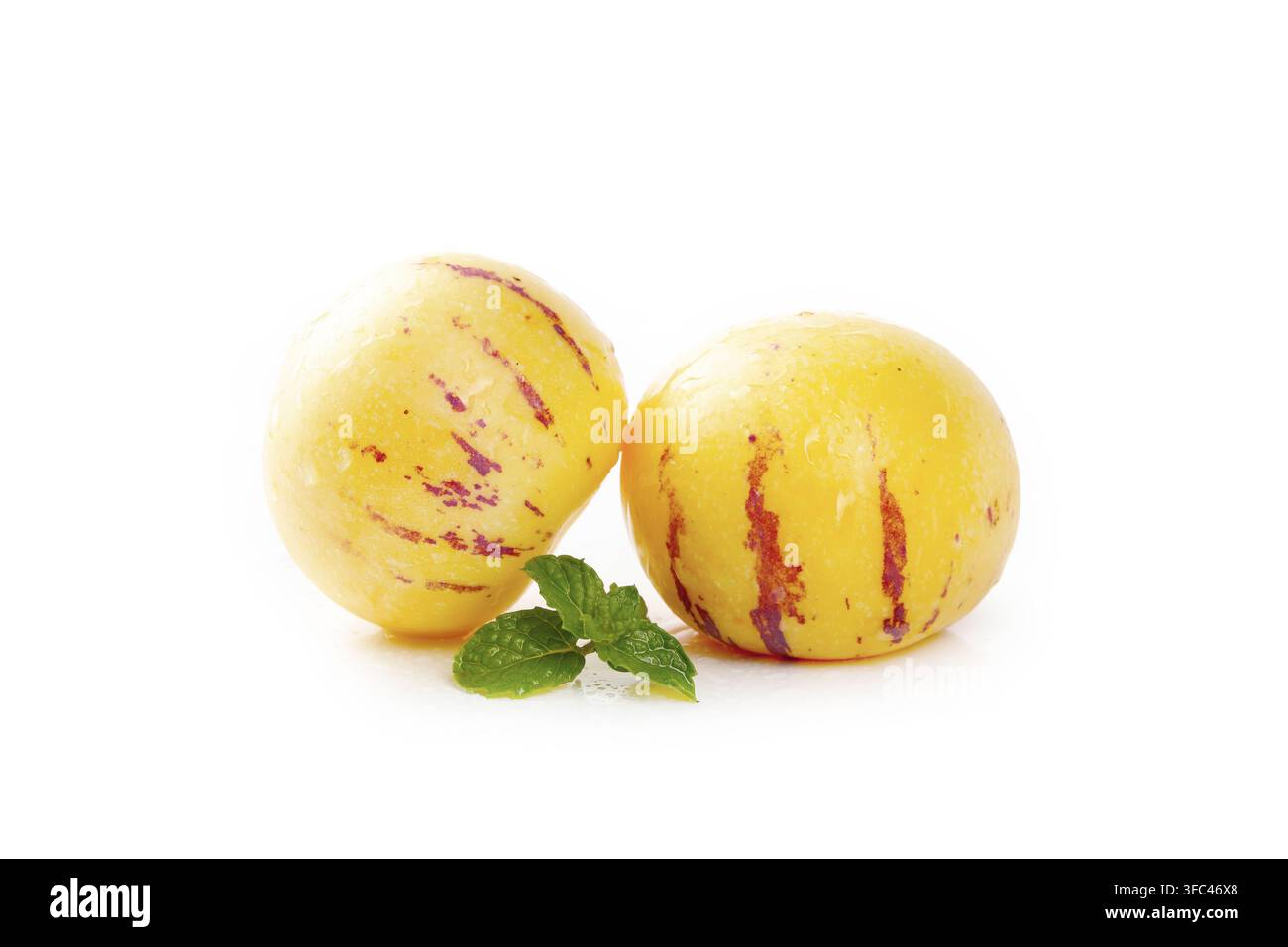 Two pepino melons with mint leaves isolated on a white background. Stock Photo