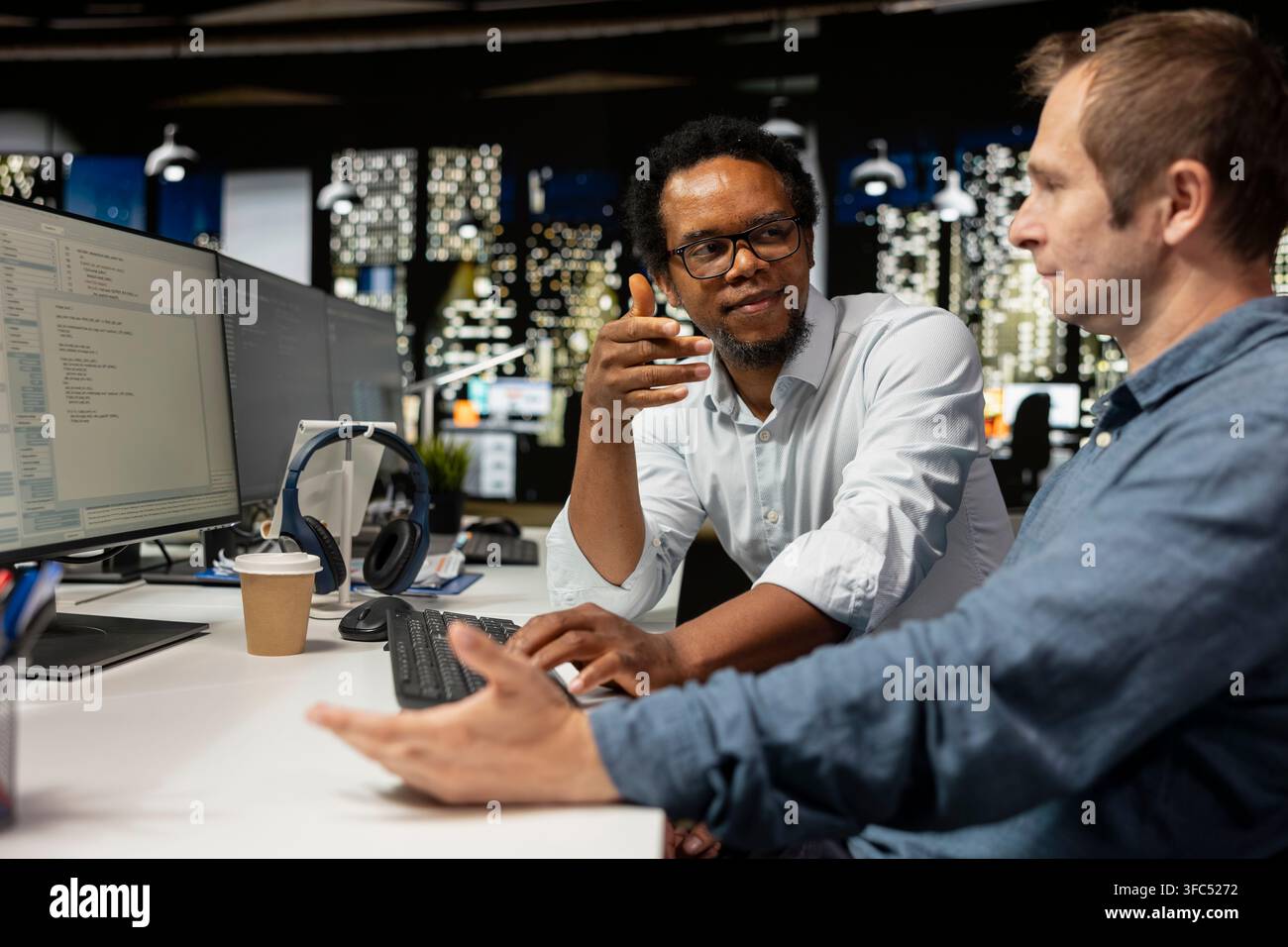 Teamworking engineers talking in startup office, coding advanced machine learning models enhancing automation. Silicon Valley workplace colleagues doing brainstorming, using AI on computer at desk Stock Photo