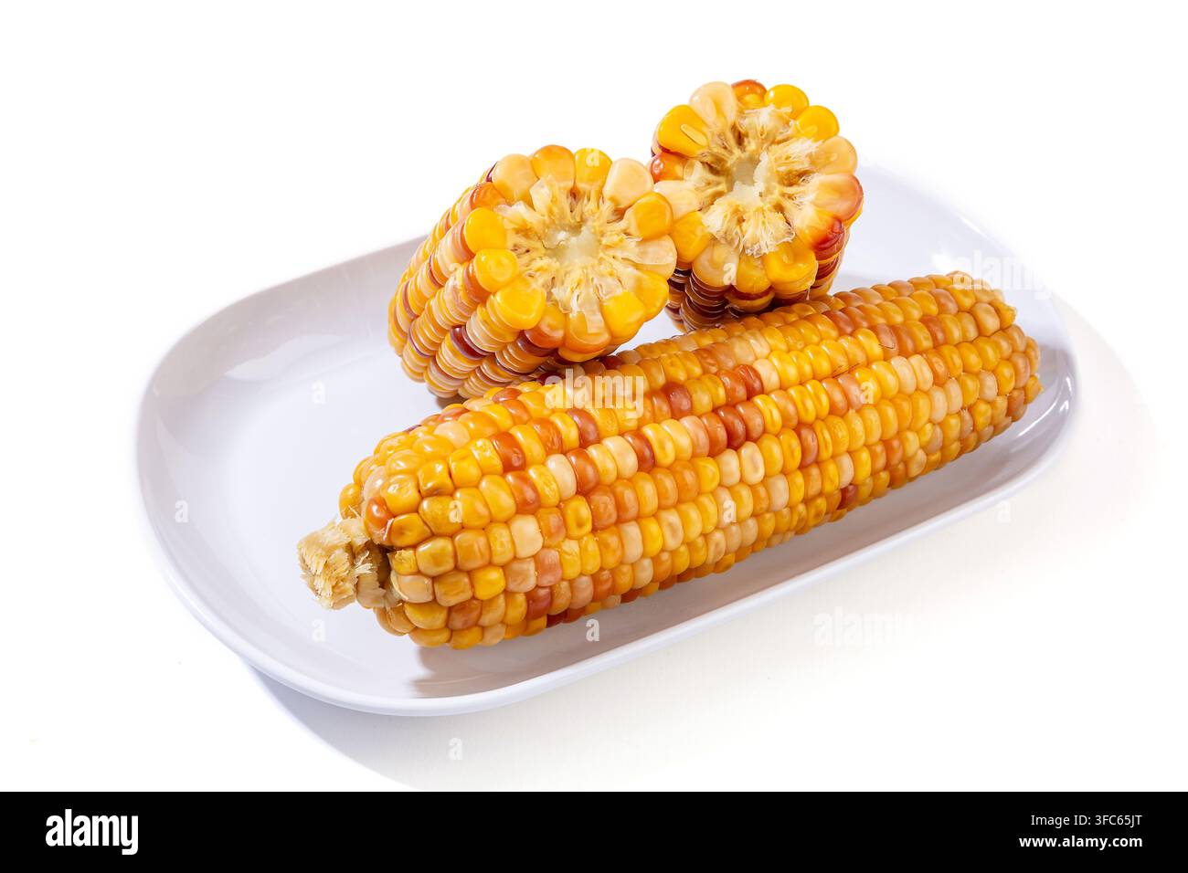 Boiled multicolored waxy corn cobs and cut segments isolated on white background Stock Photo