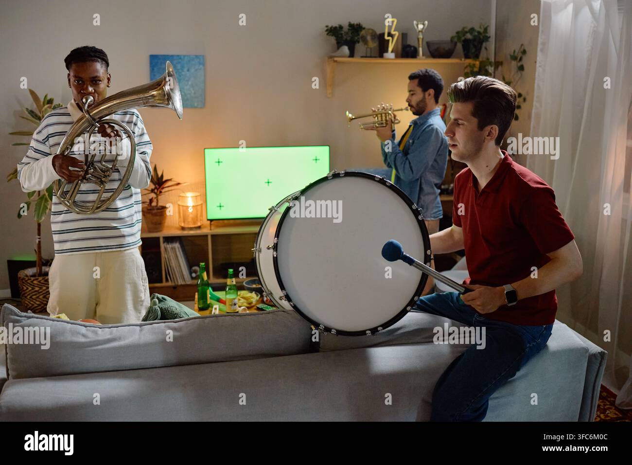 Diverse Men Playing Musical Instruments While Watching Football Game Stock Photo